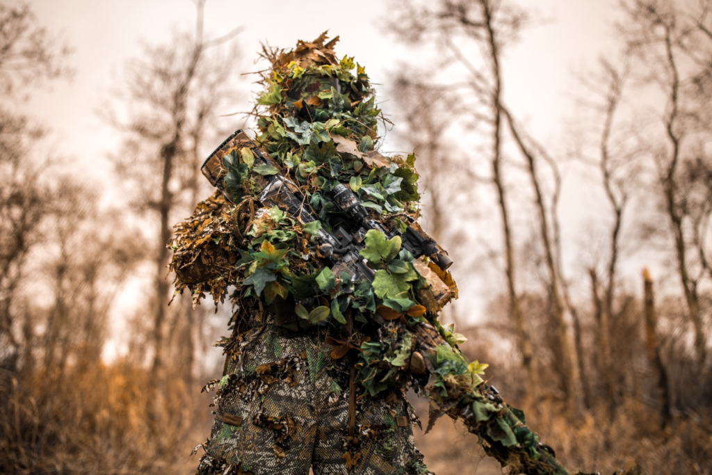 image of man in ghillie suit in the woods